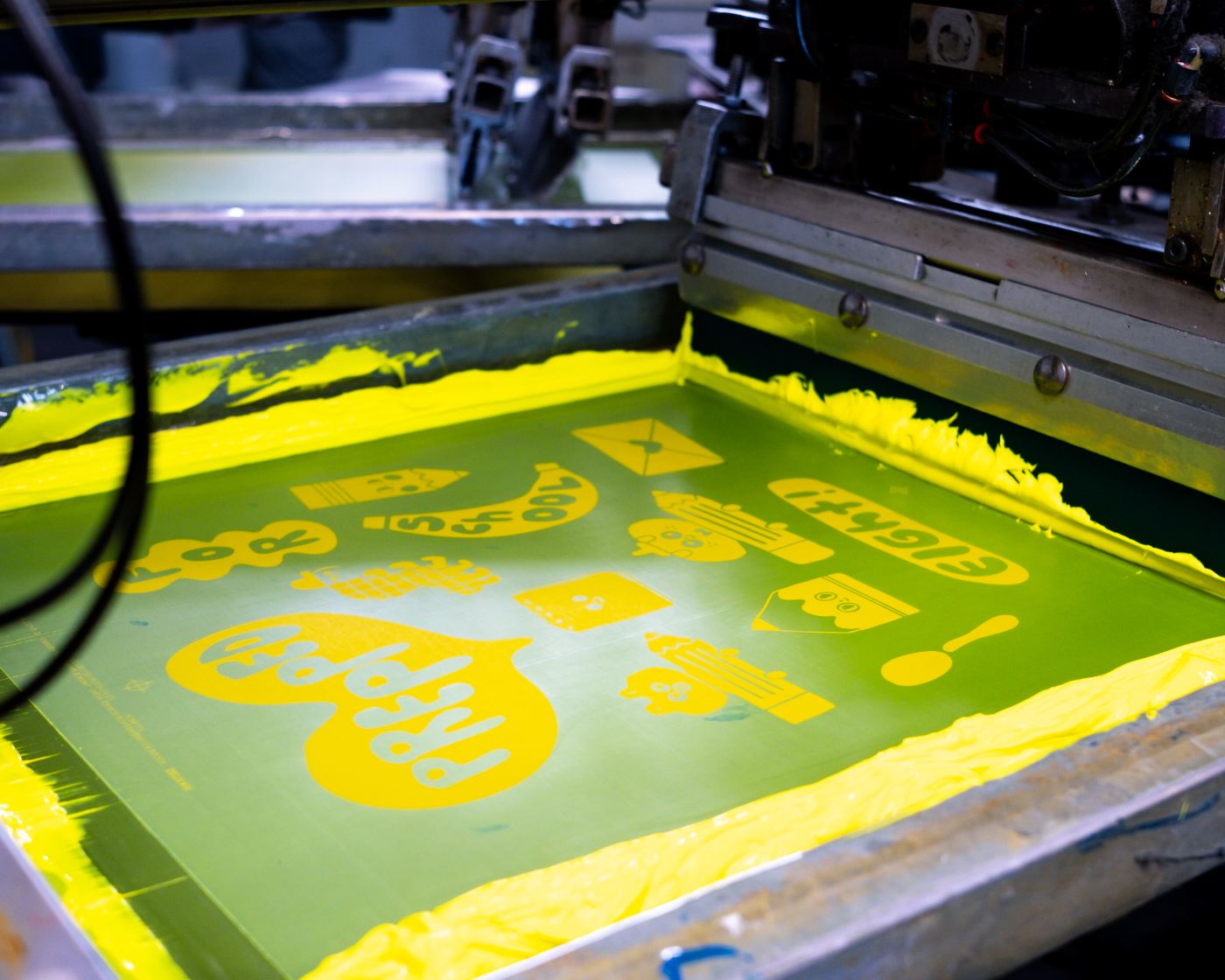 Screen prepared with yellow artwork ready for the press